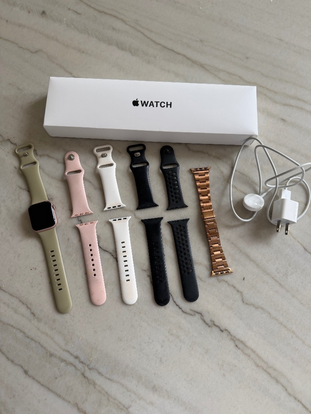 Apple Watch SE with multiple bands and charger